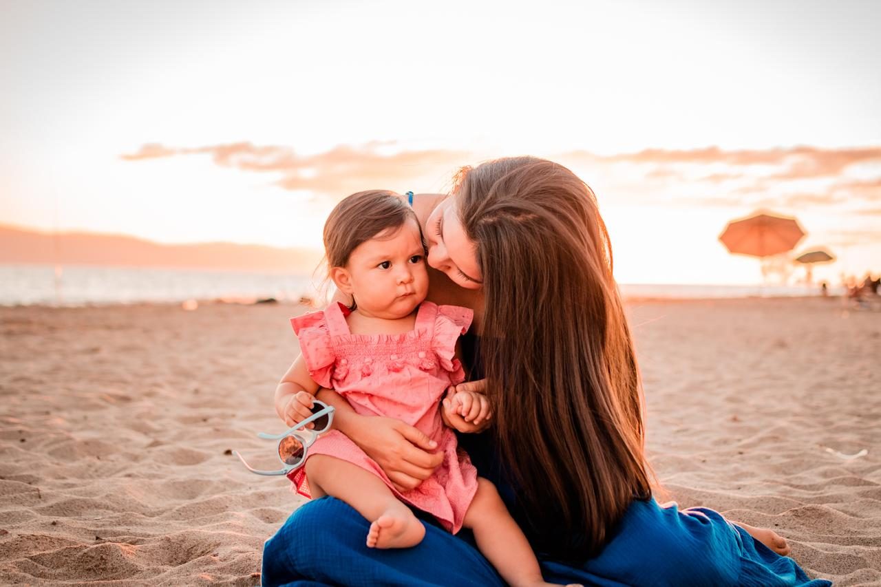 A We Care caregiver holding a child close at sunset on the beach