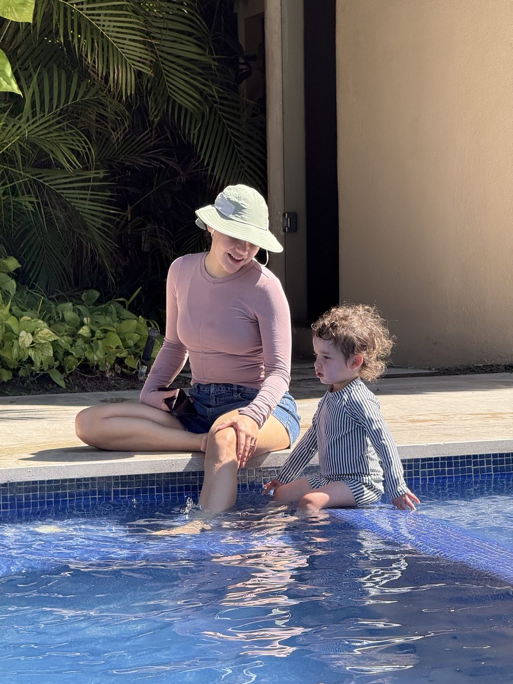 A nanny and children playing in a villa pool
