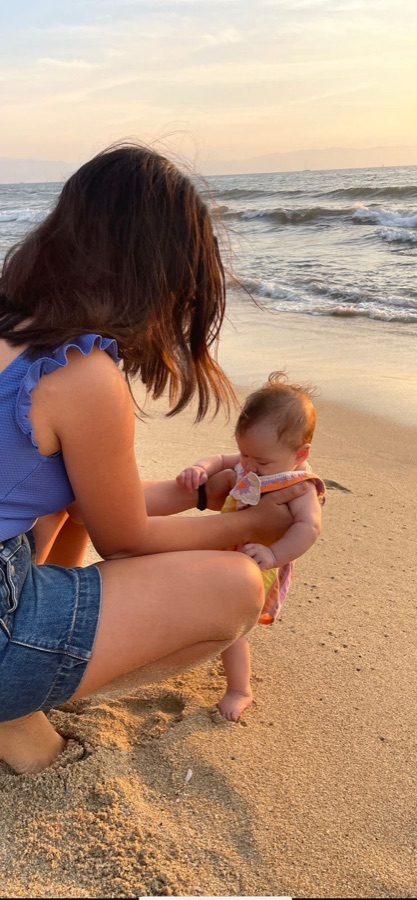 A We Care nanny and a child watching the sunset together on the beach